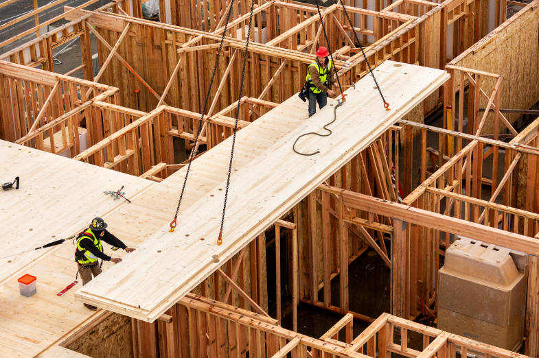 Construction workers installing CLT panel